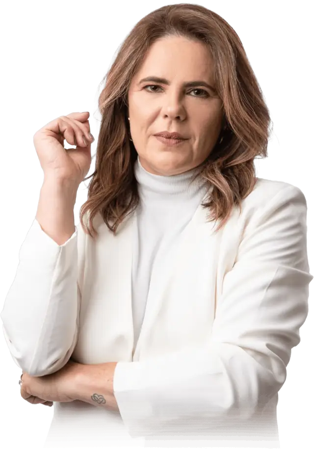 Dra. Michelly Ribeiro, de blazer branco, com os braços cruzados